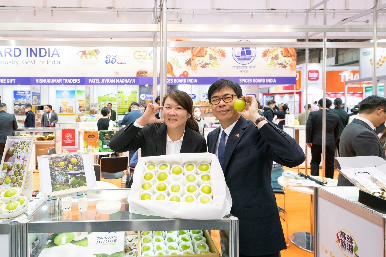 高雄市長陳其邁（7日）於東京食品展，與展場同仁比臉頰愛心行銷蜜棗